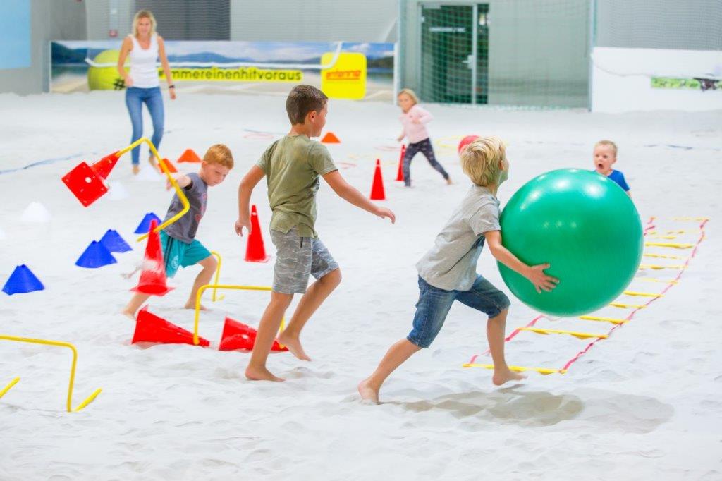 Kinder spielen im Sand der PLAY2GETHER-Beachhalle in Klagenfurt